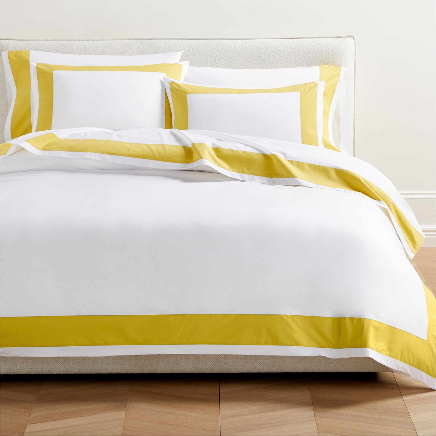 Yellow Wide-Band Percale Pillow Shams and duvet cover set on a bed.