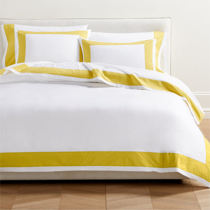 Yellow Wide-Band Percale Pillow Shams and duvet cover set on a bed.