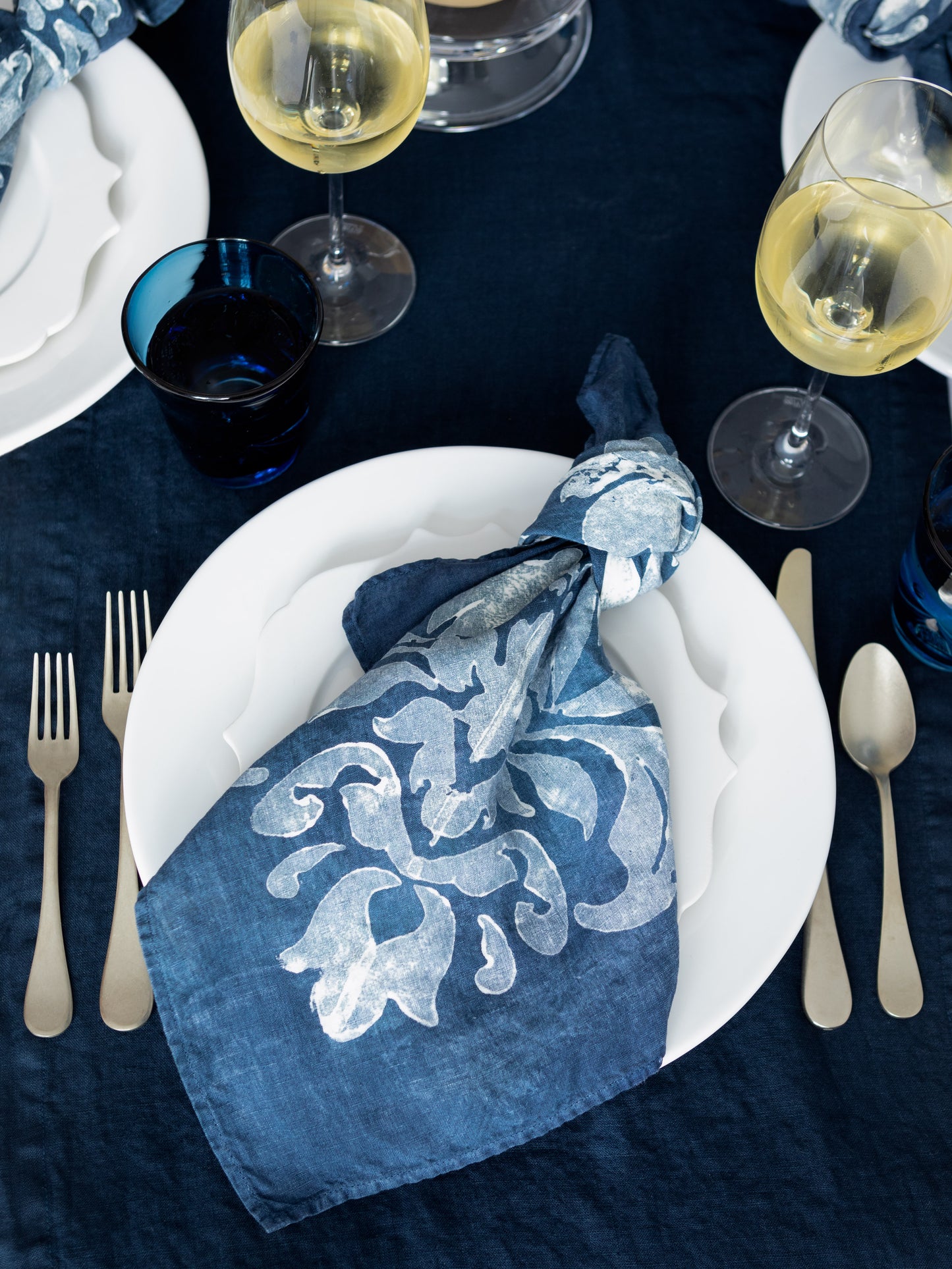 blue table setting with pale gold flatware