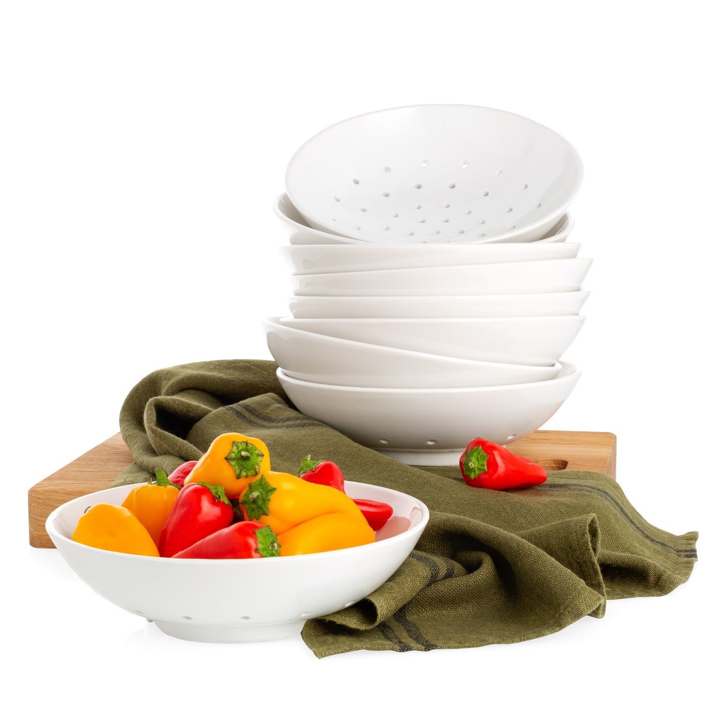 Hudson Grace White Ceramic Berry Bowl stacked with red and yellow peppers, a green towel and wood serving board