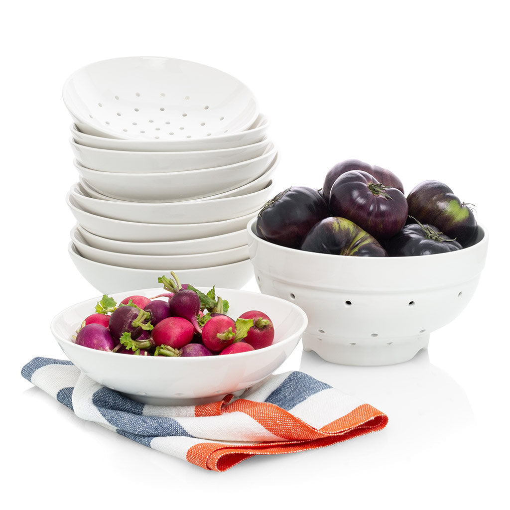 White ceramic Berry Bowl and Colander set with radishes and tomatoes, on a striped towel.