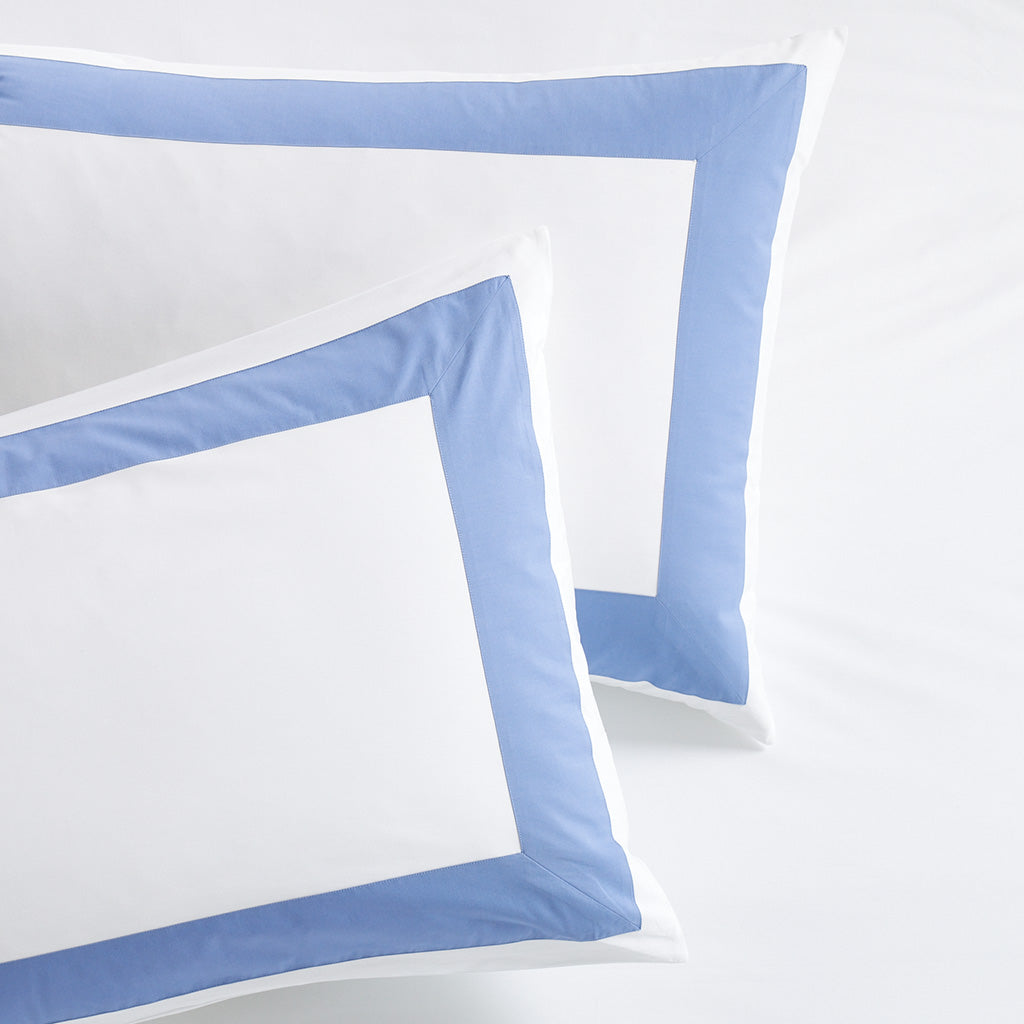 Set of 2 white percale pillow shams with a 4-inch wide blue appliqued border.
