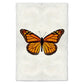 Monarch butterfly print on textured handmade paper, orange and black wings, white background.