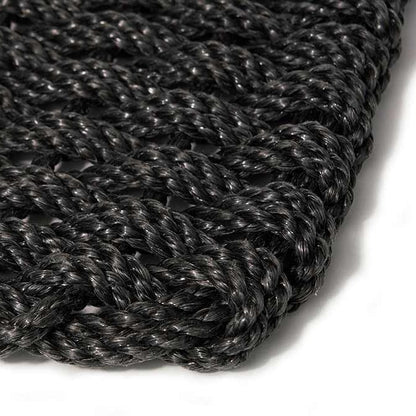 Close-up of a handwoven charcoal braided rope doormat, showing its textured, durable weave.