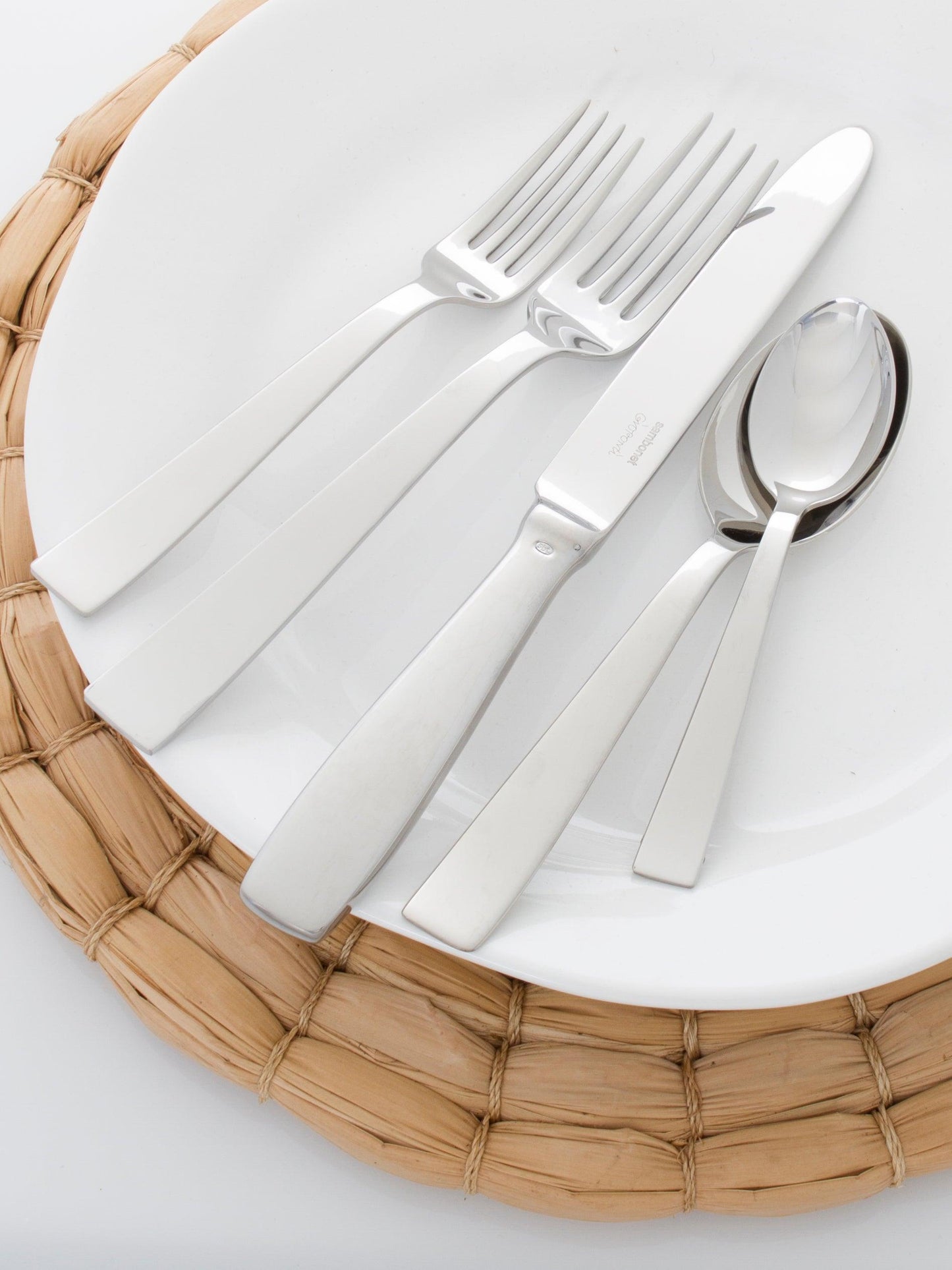 Chunky natural seagrass round woven placemat, 16", under a white plate with modern silverware.
