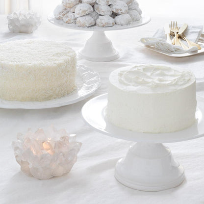 Clear Classic Quartz Votive Candle Holder, 6.5"Dia x 5.5"H, with a lit candle on a white table.