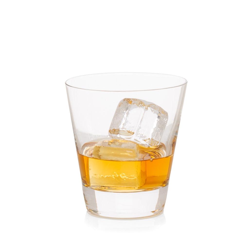 Clear crystal whiskey glass with amber liquid and ice cubes.