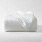 Diamond White Cotton Matelassé Coverlet, folded, showing subtle geometric pattern and rich texture.