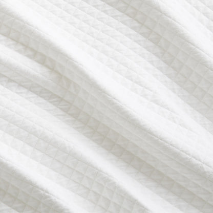 Close-up of a Diamond White Cotton Matelassé Pillow Sham with a subtle quilted diamond pattern.