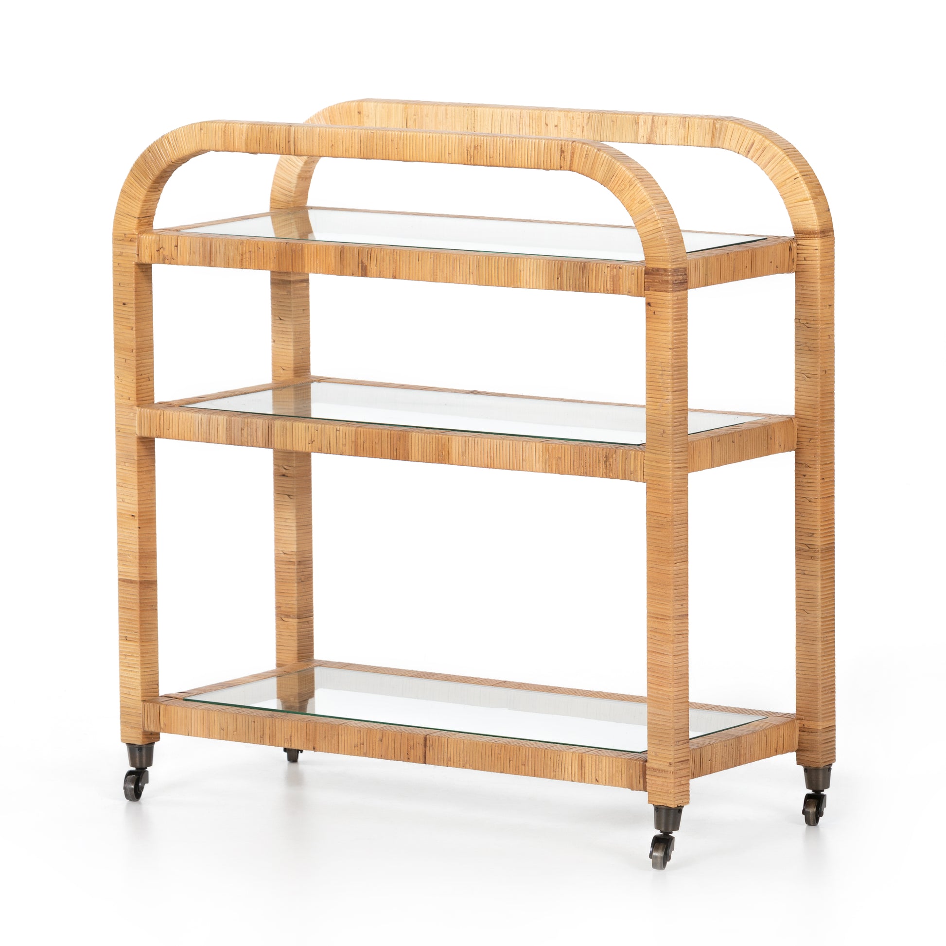 Honey-finished rattan Dory Bar Cart with three glass shelves and caster wheels.
