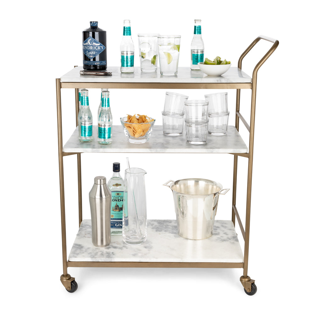 Felix antique brass bar cart with three white marble rectangular shelves, on casters.