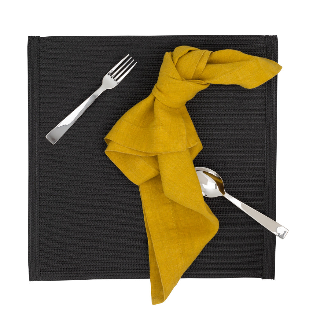 Golden Mustard HG Signature hand-dyed linen napkin, 22" square, knotted on a dark placemat with silverware.