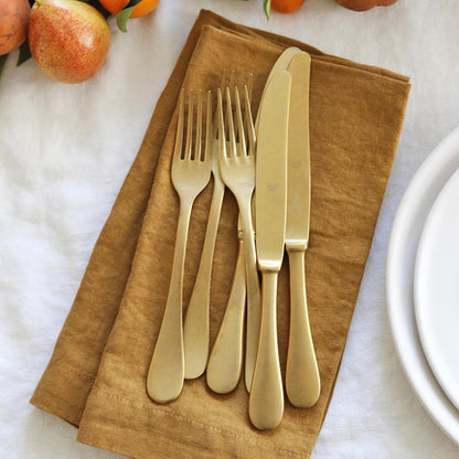 Goldenrod HG Signature hand-dyed linen napkin, 22" square, with mitered corners, under gold flatware.