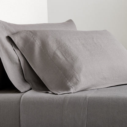 Set of two grey washed-linen pillowcases with double-needle stitch detailing on a matching linen sheet.