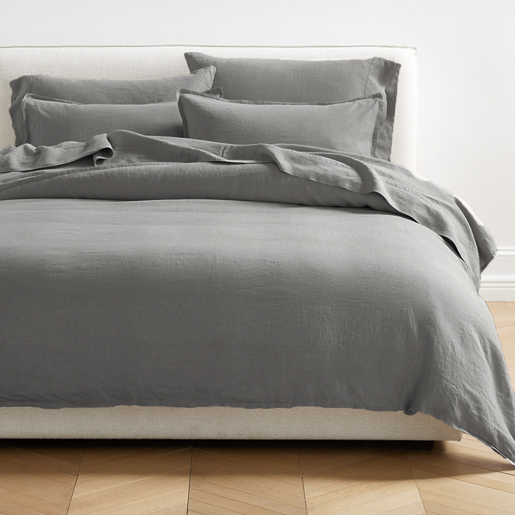 Grey washed-linen duvet cover and shams on a bed, showing the relaxed texture and 2" flange.