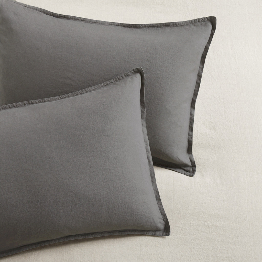 Set of two grey washed-linen pillow shams with 2" flange and double-needle stitching.