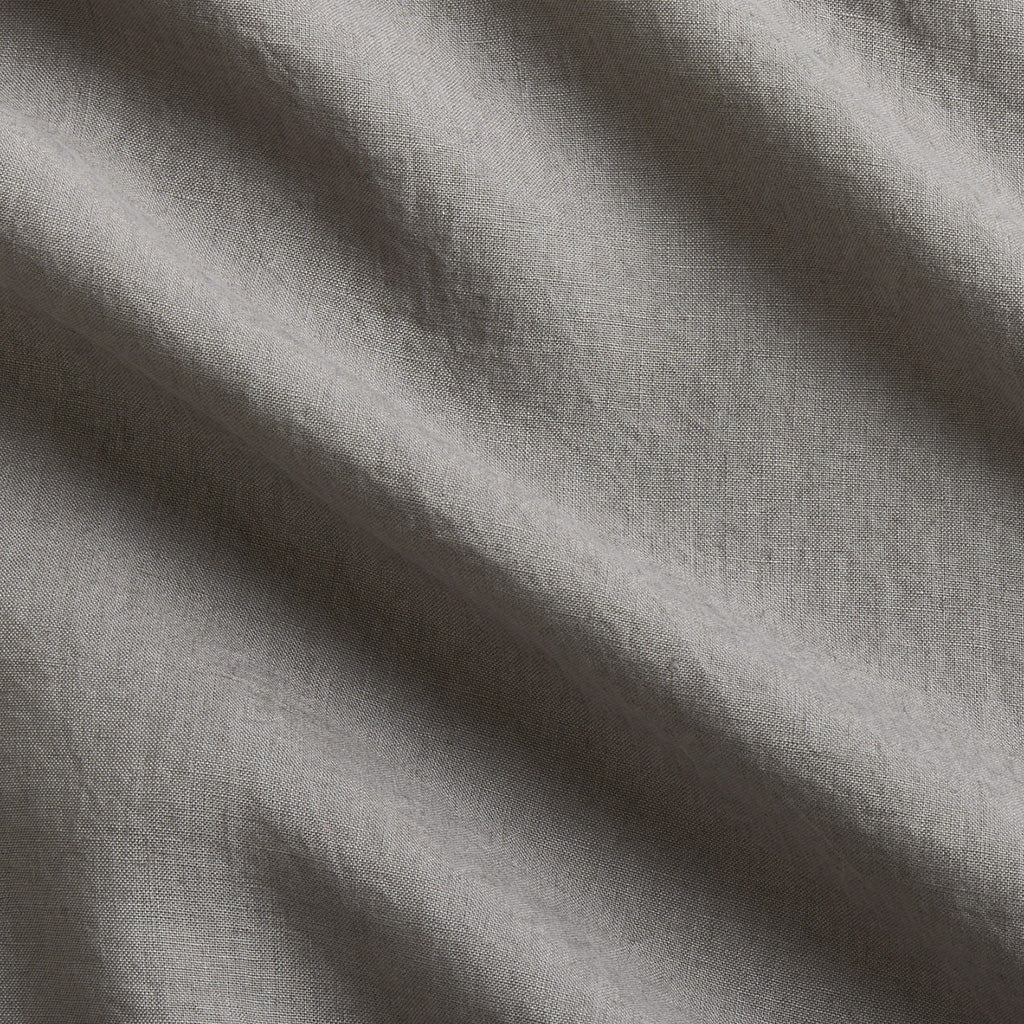 Close-up of a grey washed-linen sheet set, showing the fabric's texture and natural wrinkles.