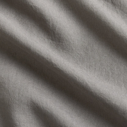 Close-up of a grey washed-linen sheet set, showing the fabric's texture and natural wrinkles.