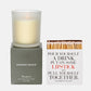 Hudson Grace Brentwood scented candle in frosted glass on a gray box, beside a white matchbox with "Pour Yourself a Drink" text.