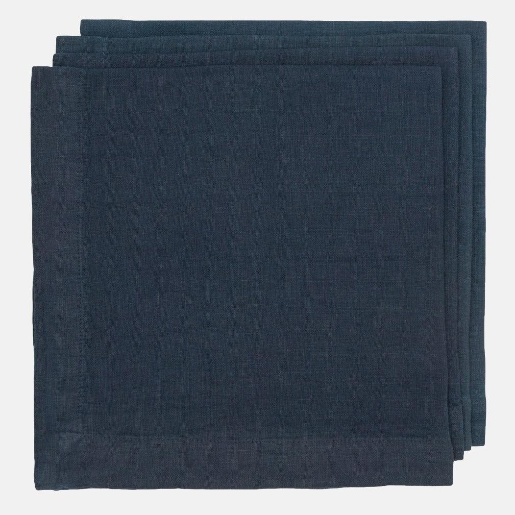 Stack of three Indigo HG Signature hand-dyed 22-inch linen napkins with mitered corners.