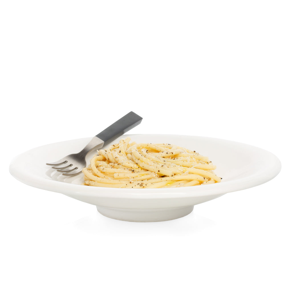 White ceramic individual pasta bowl with spaghetti, pepper, and a fork.