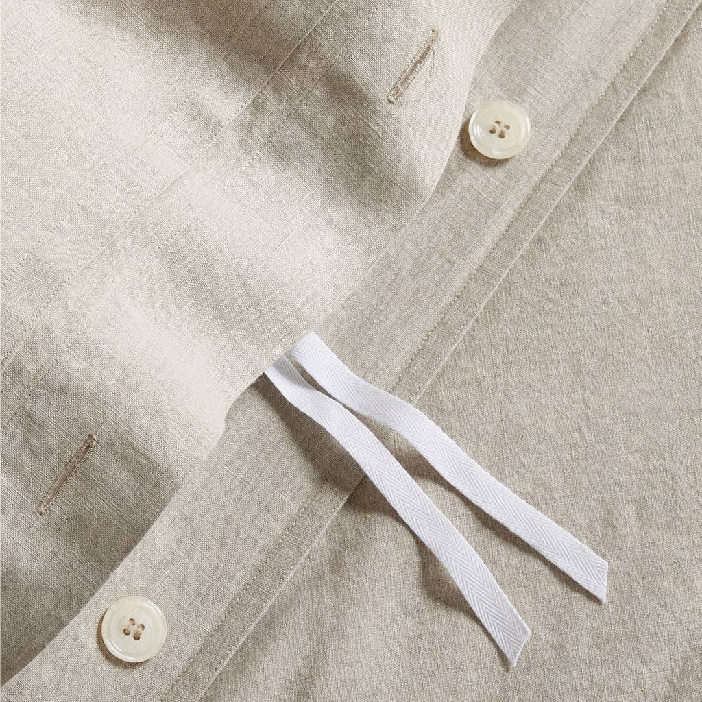 Close-up of a Khaki Washed-Linen Duvet Cover showing a hidden-button closure, corner ties, and natural texture.