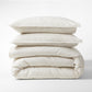 Khaki Stripe Cotton-Chambray Duvet Cover and two shams, stacked, with thin woven stripes.