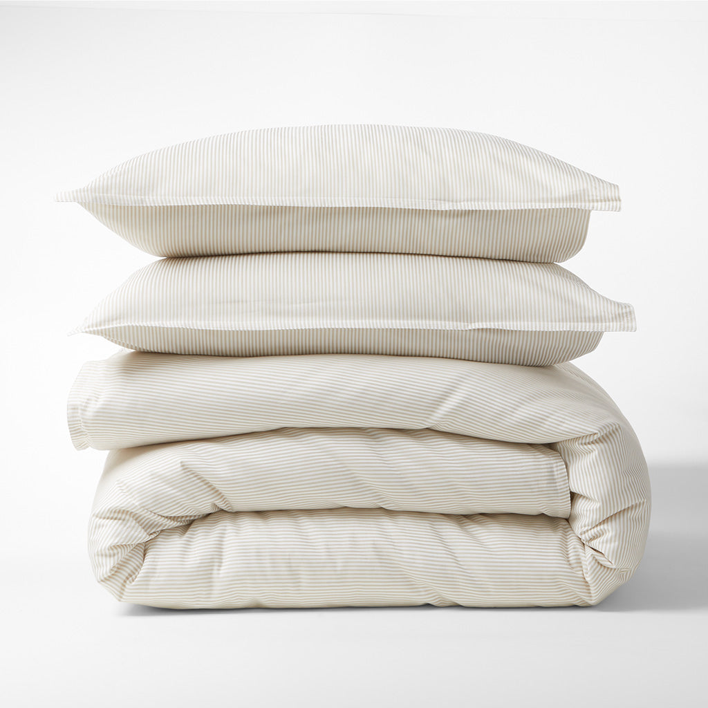Khaki Stripe Cotton-Chambray Duvet Cover and two shams, stacked, with thin woven stripes.