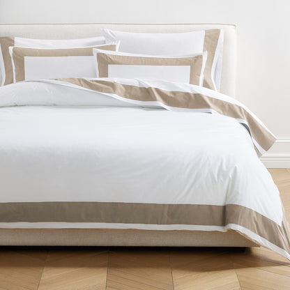 Khaki Wide-Band Percale Duvet Cover and shams on a bed, featuring a crisp white body with a 4" khaki border.