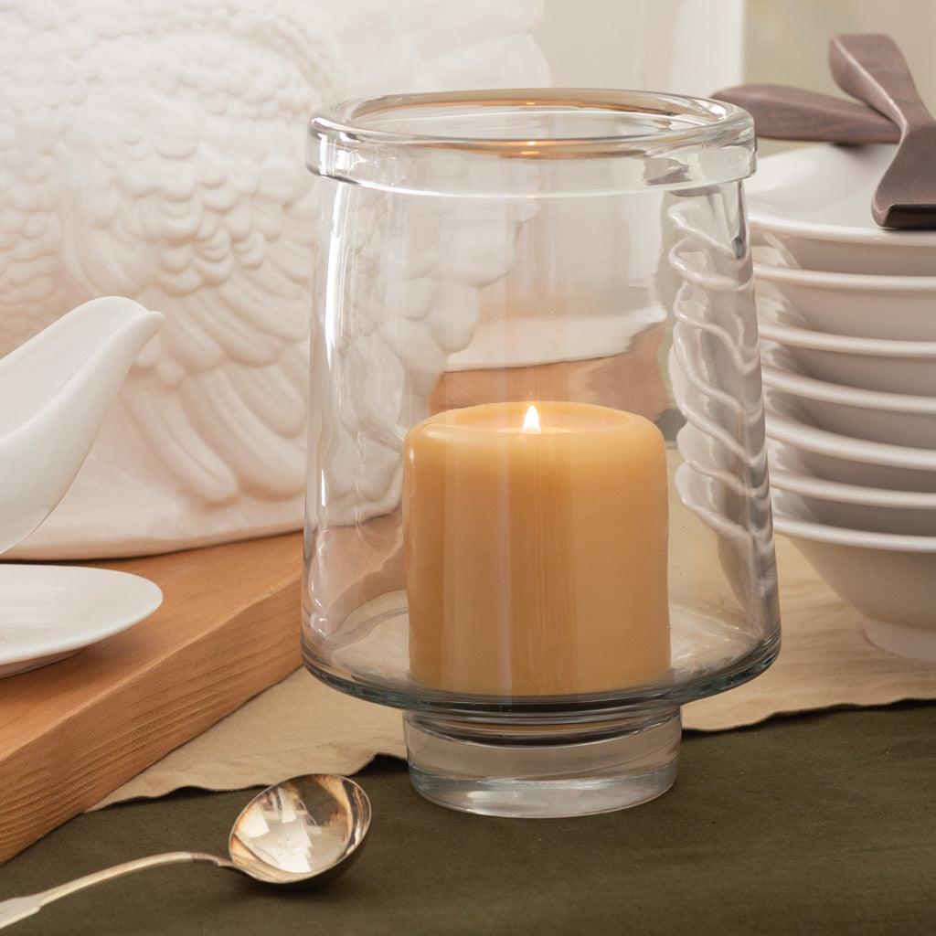 Large clear glass Antwerp Hurricane candle holder with a lit pillar candle.