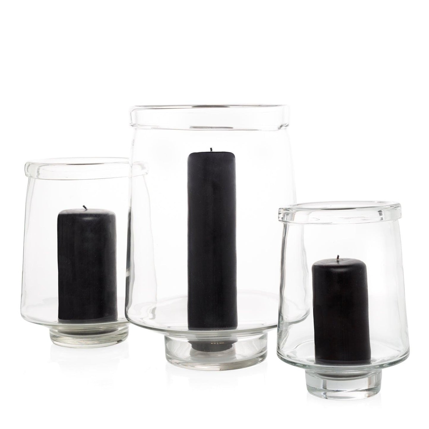 Three clear glass Antwerp hurricane candle holders, varying sizes, each with a black pillar candle.