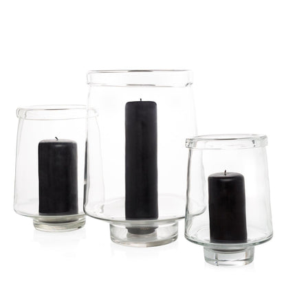Three clear glass Antwerp hurricane candle holders, varying sizes, each with a black pillar candle.