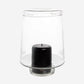 Large Antwerp clear glass hurricane candle holder with a black pillar candle inside.