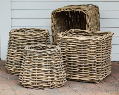 Set of four woven wood rattan planter baskets in varying sizes, natural sandblasted finish.