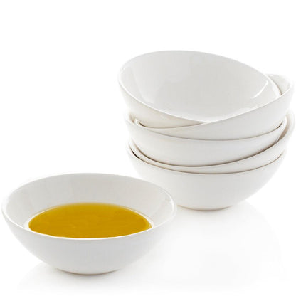 Creamy white ceramic dipping bowls, one filled with olive oil, a stack of four behind it.