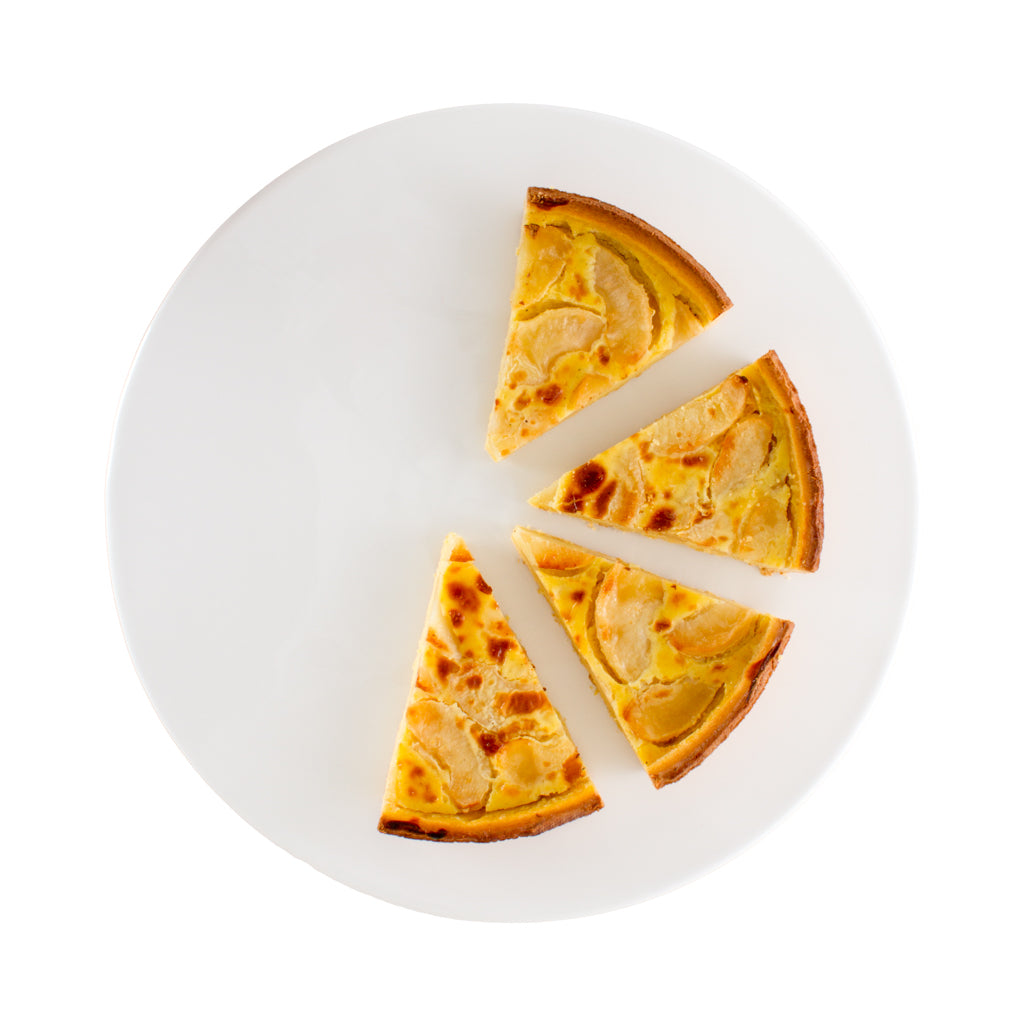 White round ceramic serving platter with four slices of apple tart.