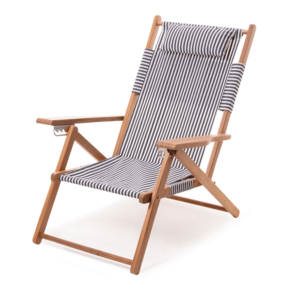 Navy and white stripe canvas reclining outdoor beach chair with a hardwood frame and padded headrest.