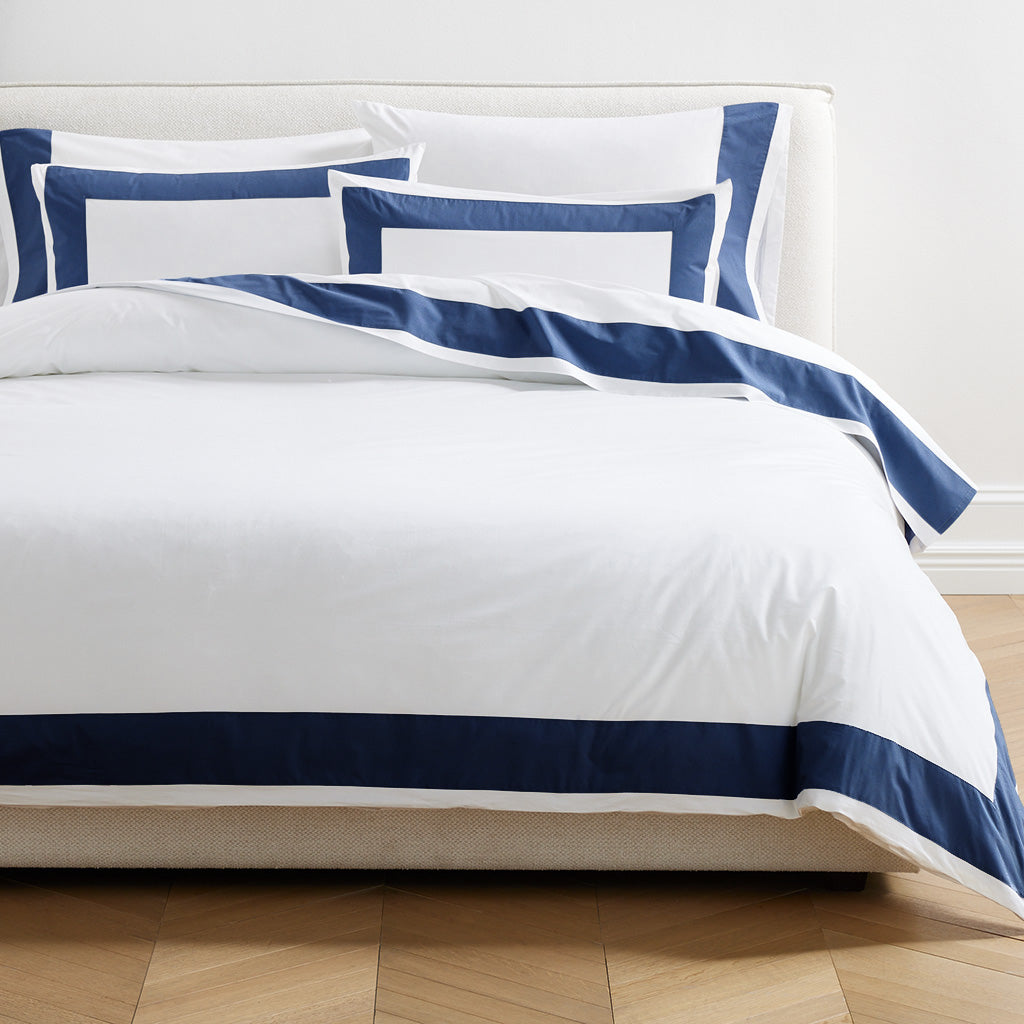 Navy blue wide-band percale duvet cover and shams on a bed.