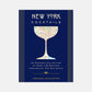 New York Cocktails book with a navy blue cover, gold stripes, and a map of NYC in a cocktail glass silhouette.
