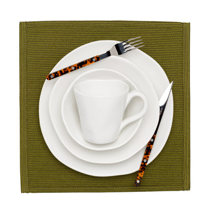 Organic Low Bowl, creamy white ceramic, 9" diameter, on a green placemat with tortoise flatware.