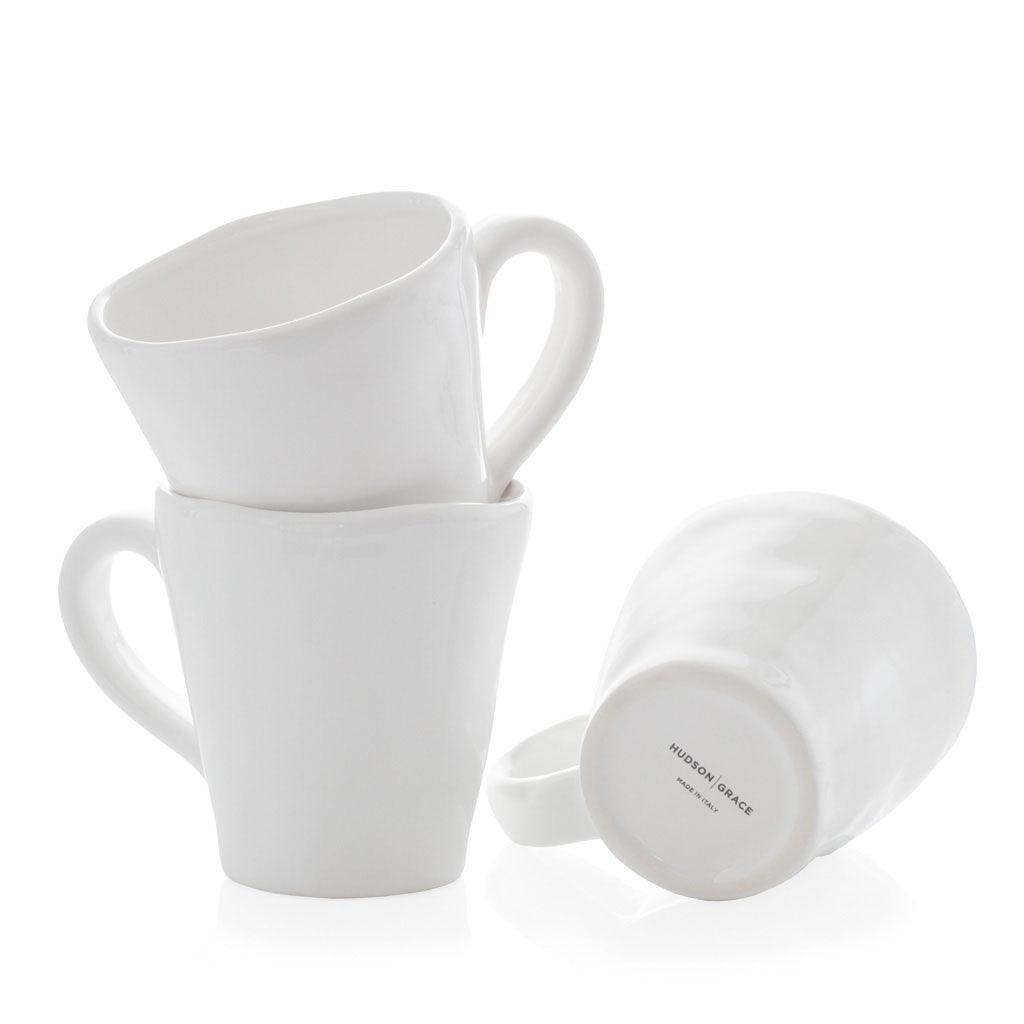 Stacked white ceramic mugs with organic edges, one showing "Hudson Grace Made in Italy" on the base.