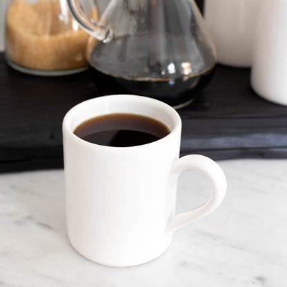 HG Original creamy white ceramic mug with coffee, 4" Diameter x 5"H, on a marble surface.
