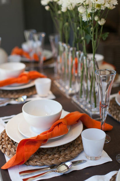 HG Original creamy white ceramic salad plate, 10" diameter, with an orange napkin on a woven placemat.