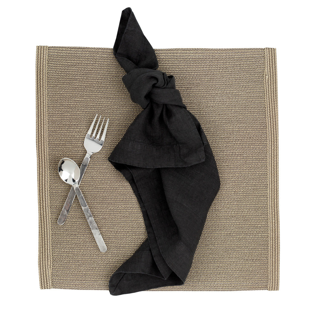 Orleans 5-piece stainless steel flatware set with hand-hammered texture, black napkin, and woven placemat.
