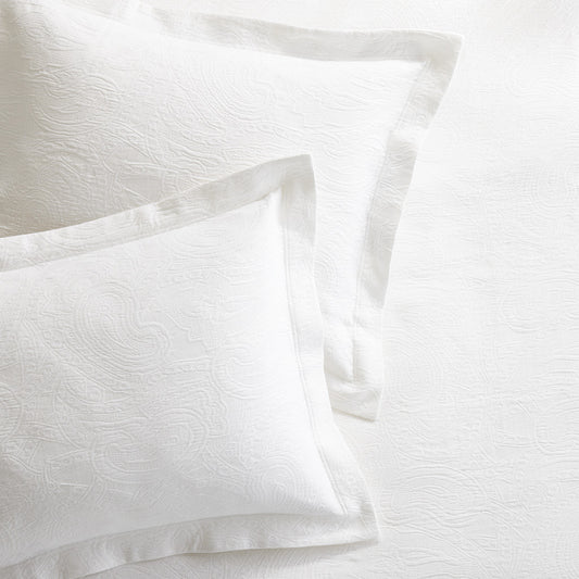 White cotton matelassé shams with subtle paisley pattern and tailored 2-inch hem.