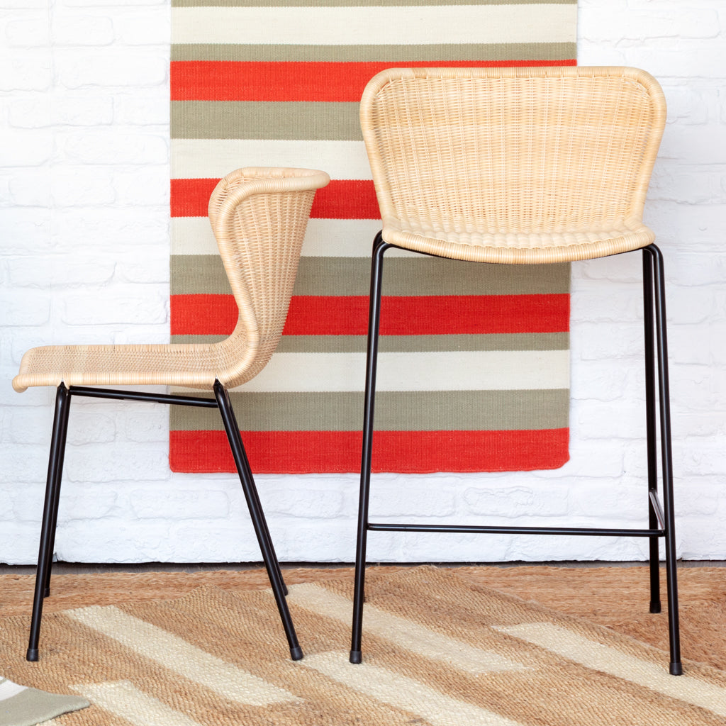 Two Rattan "Wing" Indoor Dining Chairs by Yuzuru Yamakawa with natural wicker seats and black steel frames.