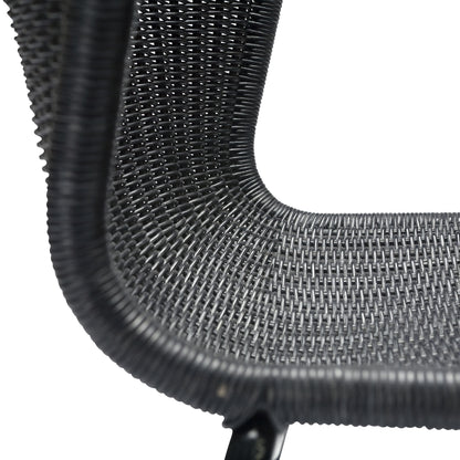 Close-up of a black rattan "Wing" outdoor dining chair with a woven polyethylene wicker seat and steel frame.