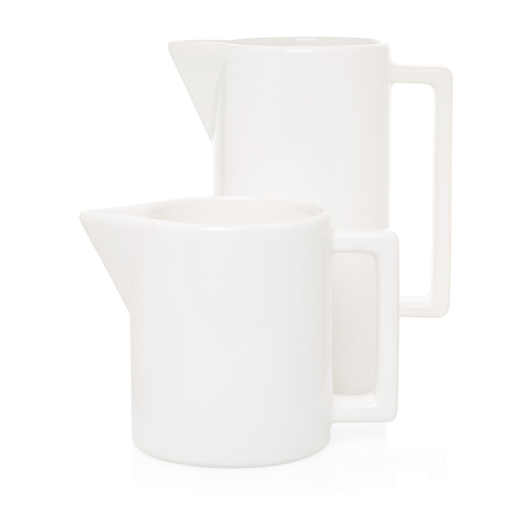 Two white ceramic pitchers, one large with a rectangular handle, one smaller.