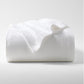 Folded white ribbed cotton matelassé coverlet with subtle texture.