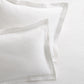 Set of 2 white ribbed cotton Matelassé pillow shams with tailored edges.